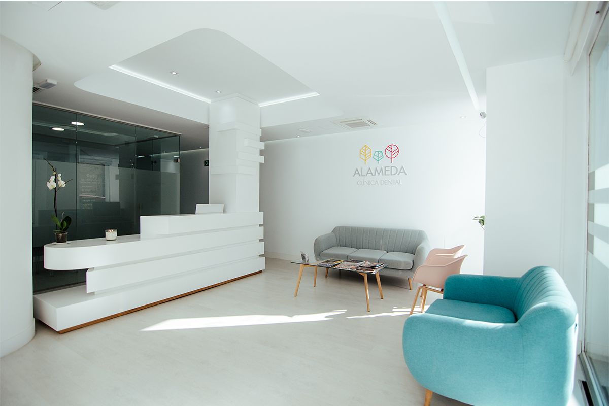 Vista general de la recepción y la sala de espera con sofás en los colores de la marca
